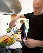 A couple preparing salad in a kitchen