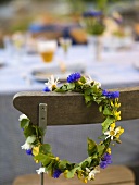 Flower wreath for a midsummer celebration hanging on a chair