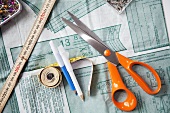 Sewing accessories: pattern, scissors, measuring tape, pencils and needles