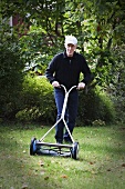 Old man with a push lawn mower