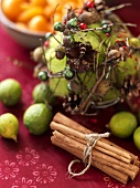 Christmas arrangemnt with cinnamon sticks, frui & pine cones