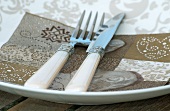 A brown patterned napkin and cutlery