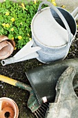 A watering can, wellies and gardening tools