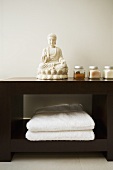 Braunes Badezimmerregal mit Buddha-Statue & Handtüchern