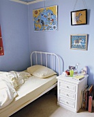 Pastellfarbenes Jungenschlafzimmer mit schlichtem Metallbett in Weiß