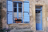 A house with open shutters in the village of Lauris in Luberon