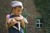 A girl holding a piglet