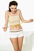 Young woman with a tape measure round her waist