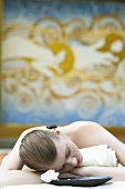 Young woman having LaStone Therapy (hot & cold stone massage)