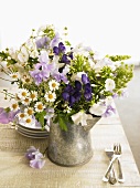 Jug of summer flowers: sweet peas, chamomile, monkshood, phlox