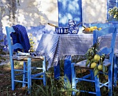 Table with blue and white tablecloth, crockery and lemons
