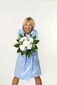 Smiling woman showing bouquet of white roses