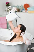 Woman in bubble bath pouring water over head