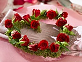 Heart-shaped wreath of red roses on place-setting