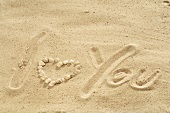 The words I love you with shells in sand