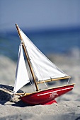 Spielzeugsegelboot am Sandstrand