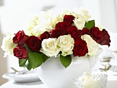 Arrangement of red and white roses on laid table
