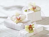 Gifts in white wrapping paper with orchids