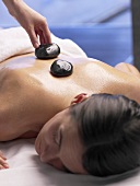 Woman having a warm stone massage