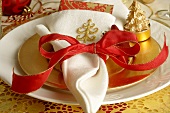 Christmas place-setting with white napkin and red bow