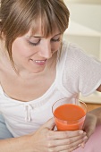 Woman holding glass of carrot juice