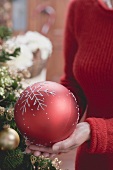Woman holding large red Christmas bauble