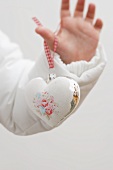 Child's hand holding Christmas tree ornament