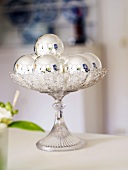 Christmas table decoration (silver baubles on glass stand)