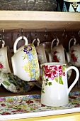 Cups and a jug on a shelf