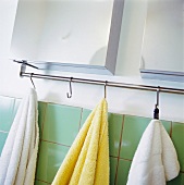 Towels hanging on hooks in a bathroom