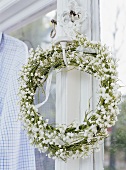 Wreath of white flowers by window