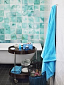 Badezimmer mit türkisfarbenen Wandfliesen und Badezimmeraccessoires