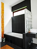 Badezimmer in Schwarz-weiß mit einer Trennwand aus Glasbausteinen