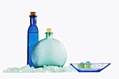 Blaue Flaschen und Badeperlen in Glasschale