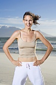 South Africa, Cape Town, Young woman exercising on beach, portrait
