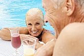 Älteres Paar mit Cocktails im Swimmingpool