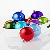 Shiny, coloured Christmas baubles on tray