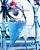 Frozen berries in a pointed cone as winter decoration on a garden fence