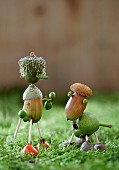 Dog and owner crafted from acorns, thistles and acorn cups