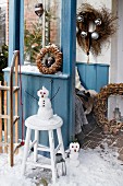 An entrance way decorated with wreaths and a snowman on a stool