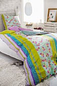 Bed with colourful, reversible bed linen