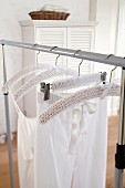 A white knitted cover hanging on a clothes hanger