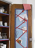 Hand-crafted, fabric note board with zigzag trim inside cupboard door