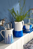 Hand-painted porcelain jugs and bowls in blue-and-white on a wall shelf in a kitchen