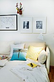 Photos and colourful, stylised hunting trophy in corner above comfortable sofa
