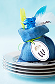 A blue chocolate Easter Bunny in bag on a stack of plates