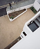House facade with a view of an outside stairway and beautifully designed forecourt with flower bed and retaining walls