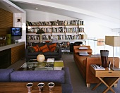 Moderner Wohnraum mit brauner Lederliege und verschieden farbigen Sofas