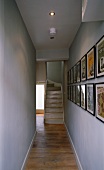Picture gallery in a narrow hallway and ascending stairs