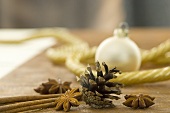 Weihnachtliches Stillleben mit Sternanis, Zimtstangen und Pinienzapf